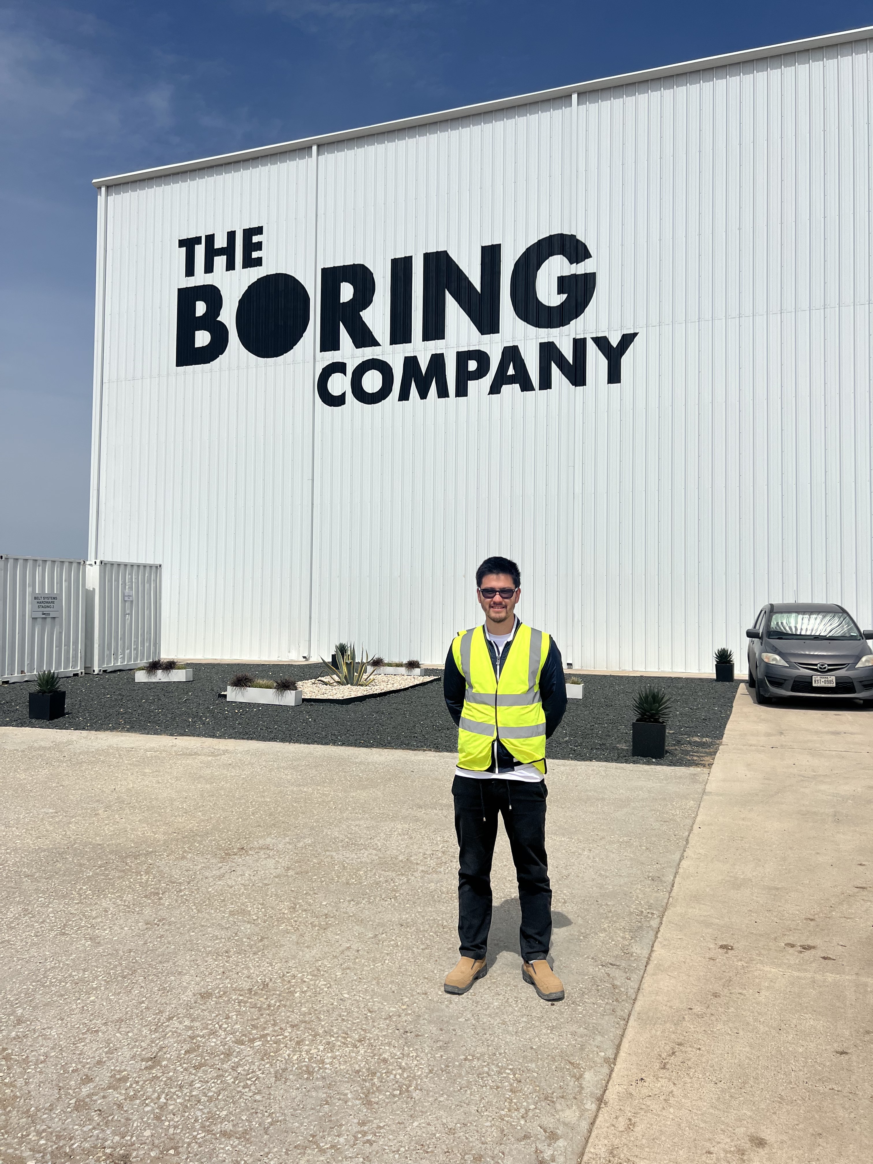 Standing in front of The Boring Company hangar in Texas